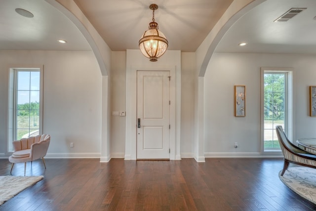 entryway featuring an inviting chandelier and dark hardwood / wood-style floors