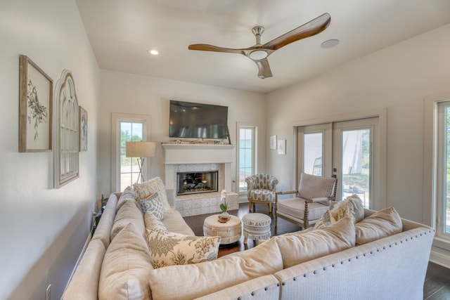 living room with ceiling fan, wood-type flooring, french doors, and a fireplace