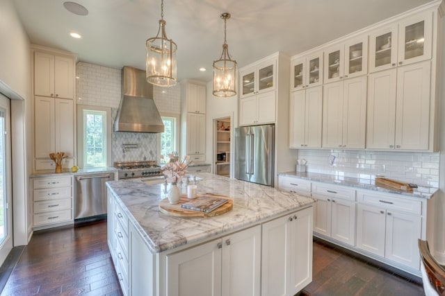 kitchen featuring wall chimney range hood, tasteful backsplash, dark hardwood / wood-style floors, and stainless steel appliances