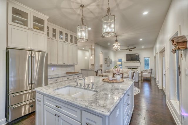 kitchen with a center island, sink, dark hardwood / wood-style flooring, decorative backsplash, and high quality fridge