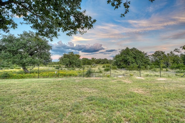 yard at dusk featuring a rural view