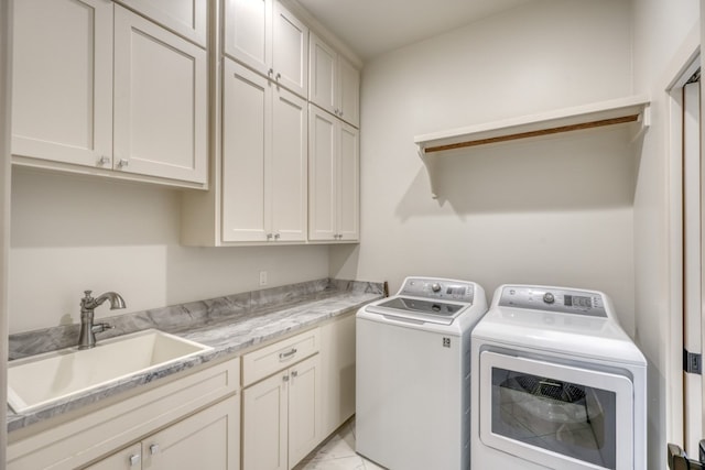 laundry area with sink, washing machine and dryer, cabinets, and light tile patterned floors