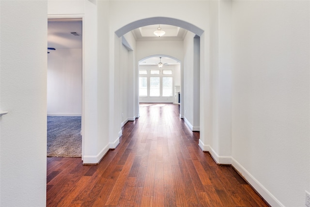 hall with dark wood-type flooring and crown molding