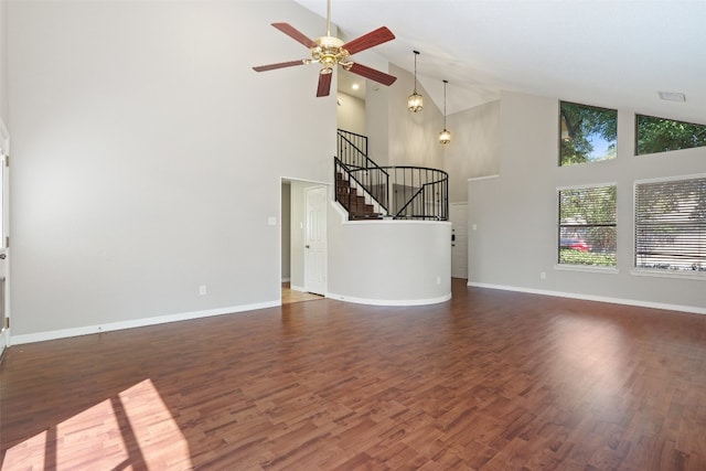 unfurnished living room with dark wood-type flooring, high vaulted ceiling, and ceiling fan