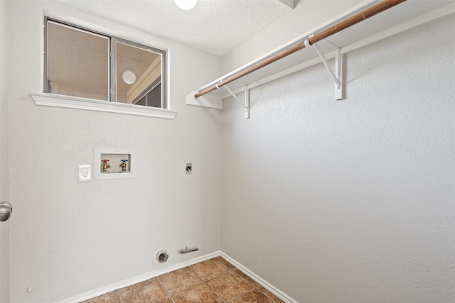 clothes washing area with tile patterned flooring, hookup for a washing machine, hookup for an electric dryer, gas dryer hookup, and a textured ceiling