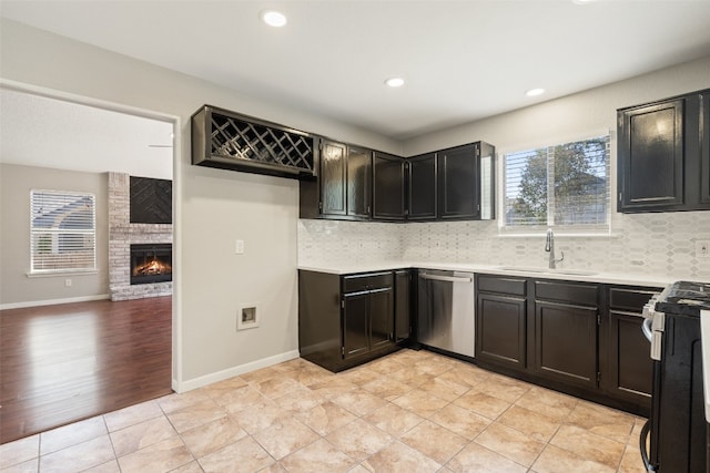 kitchen with sink, stainless steel appliances, decorative backsplash, and a wealth of natural light