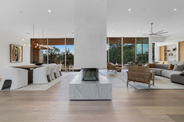 living room featuring floor to ceiling windows, wood finished floors, and a healthy amount of sunlight