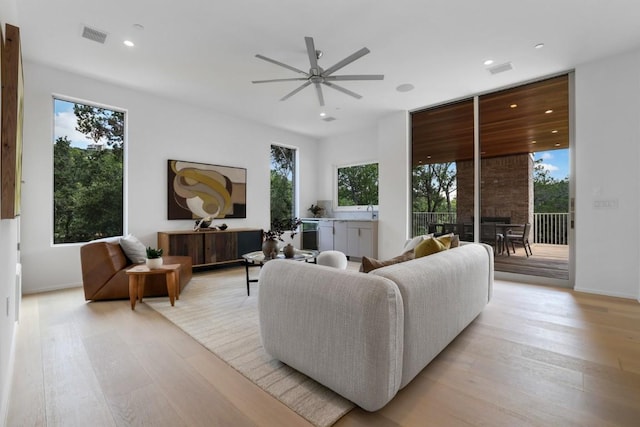 living room with light wood-style flooring, recessed lighting, visible vents, and ceiling fan