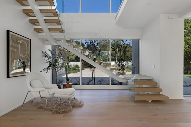 living area with stairway and wood finished floors