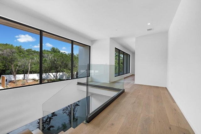 corridor with recessed lighting, visible vents, wood-type flooring, and baseboards