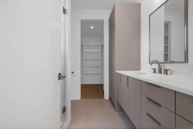 full bathroom with vanity, a spacious closet, an enclosed shower, and tile patterned flooring