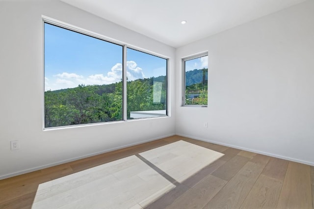 unfurnished room with recessed lighting, baseboards, and wood finished floors