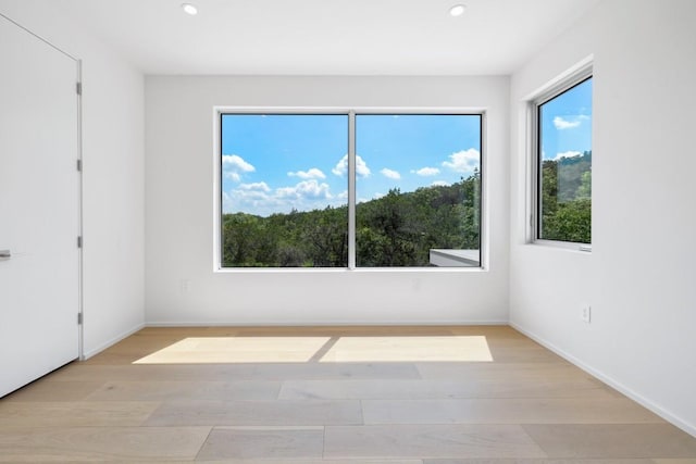 unfurnished bedroom featuring recessed lighting, light wood-type flooring, and baseboards