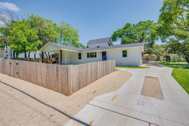 view of front of house with a carport, crawl space, a fenced front yard, and concrete driveway