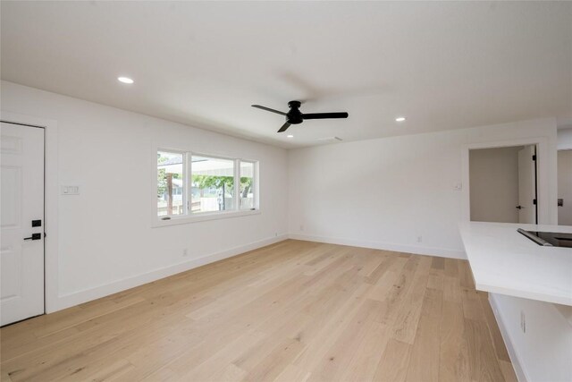 unfurnished living room featuring ceiling fan and light hardwood / wood-style flooring