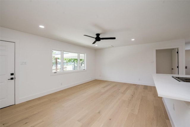 unfurnished living room with baseboards, recessed lighting, and light wood-style floors