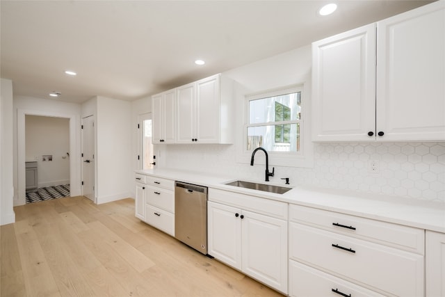 kitchen featuring decorative backsplash, light hardwood / wood-style flooring, white cabinetry, dishwasher, and sink