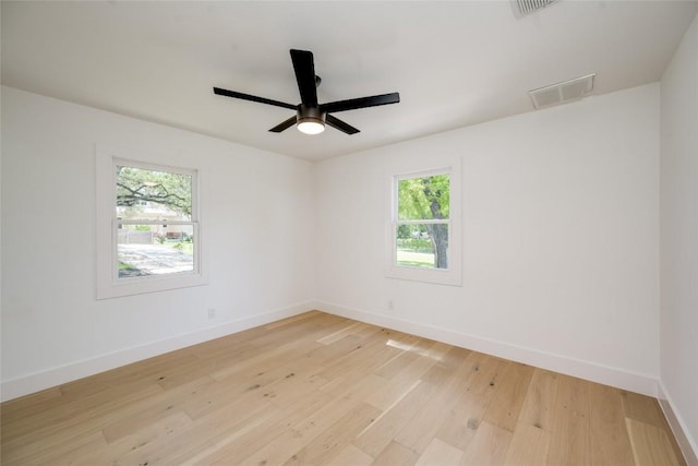 unfurnished room featuring light wood-style floors, visible vents, baseboards, and a ceiling fan