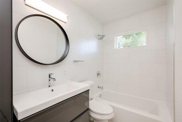 full bathroom with toilet, tiled shower / bath, and vanity