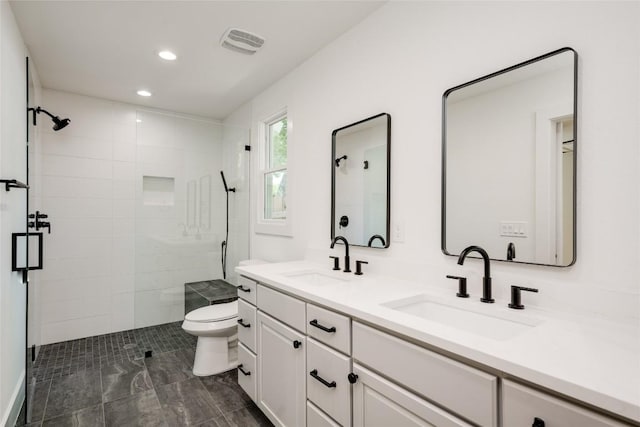 bathroom featuring a stall shower, a sink, and visible vents