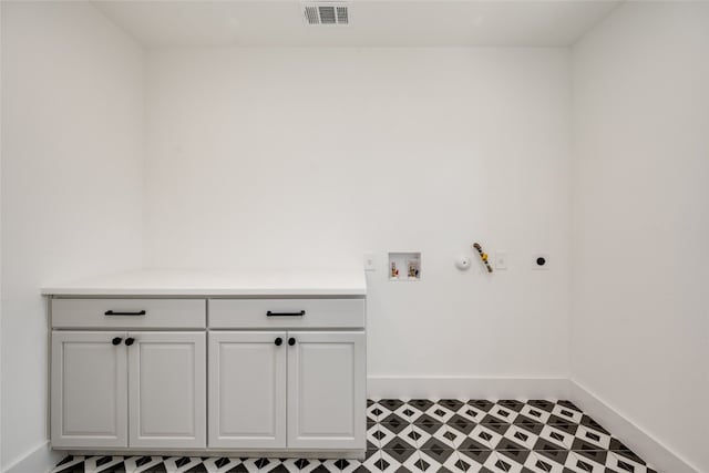 washroom featuring tile patterned floors, hookup for a washing machine, cabinets, and hookup for an electric dryer