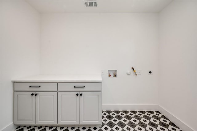 laundry room featuring cabinet space, visible vents, hookup for an electric dryer, baseboards, and tile patterned floors