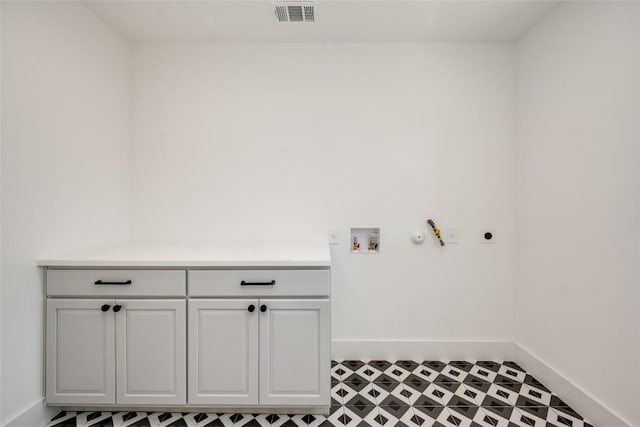 1928 Miles Ave Unit 1, Austin, TX 78745 - laundry area featuring electric dryer hookup, cabinet space, visible vents, and baseboards