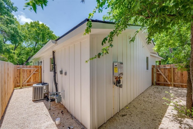 view of outbuilding featuring a gate, central AC unit, and fence