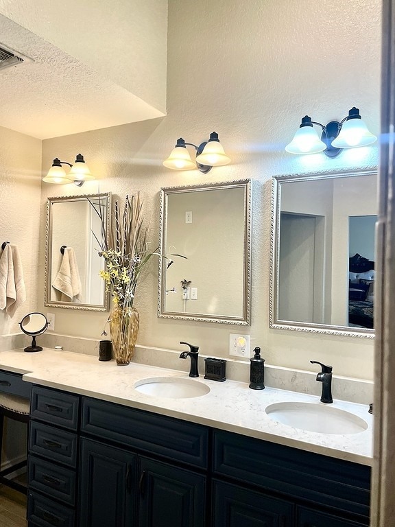 bathroom featuring double vanity and a textured ceiling