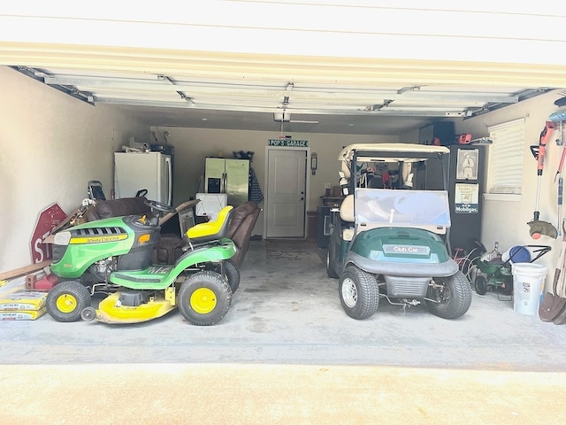 garage with white refrigerator and stainless steel fridge