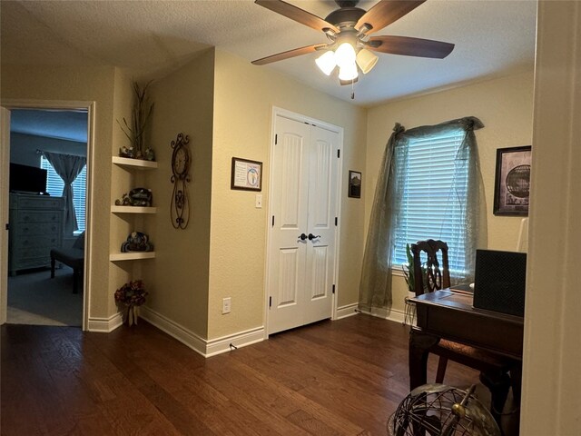 office area featuring a textured ceiling, ceiling fan, and dark hardwood / wood-style flooring