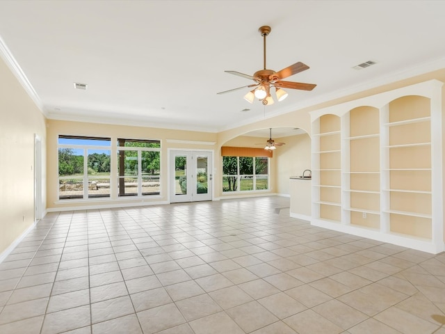 unfurnished living room featuring ceiling fan, a wealth of natural light, light tile patterned flooring, and ornamental molding