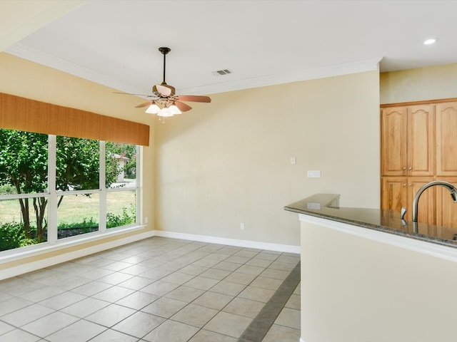 interior space featuring light tile patterned floors, sink, crown molding, and ceiling fan