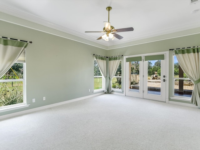 carpeted empty room featuring ceiling fan, plenty of natural light, and ornamental molding