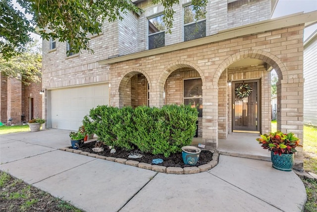 entrance to property featuring driveway and brick siding