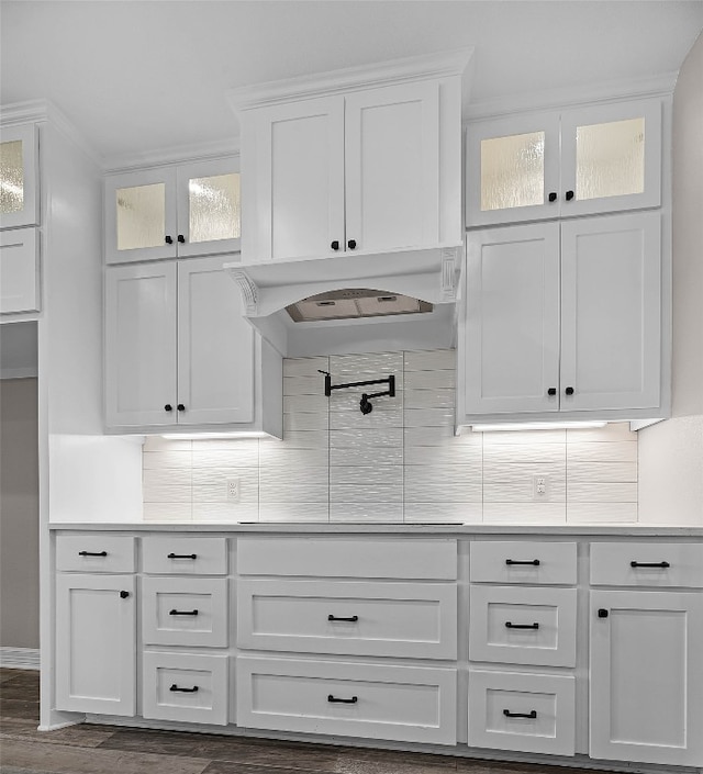 kitchen with backsplash, white cabinetry, cooktop, dark hardwood / wood-style flooring, and custom exhaust hood