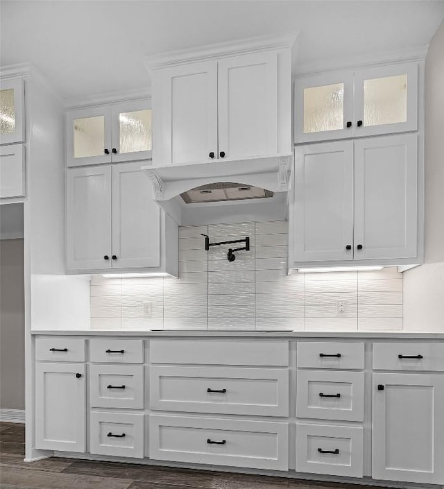 bar featuring tasteful backsplash, dark wood-type flooring, stovetop, and custom exhaust hood