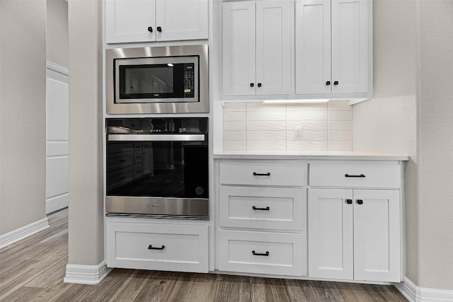 kitchen with stainless steel appliances, light countertops, and white cabinetry