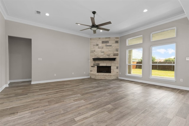 unfurnished living room with a fireplace, ceiling fan, ornamental molding, and light wood-type flooring