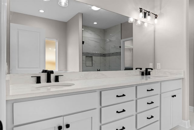 bathroom featuring a tile shower and double sink vanity