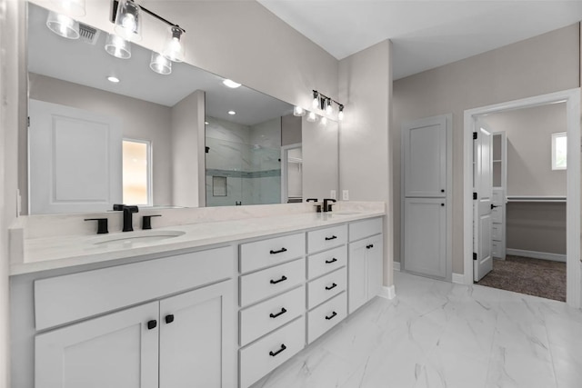 full bathroom with double vanity, a marble finish shower, marble finish floor, a walk in closet, and a sink