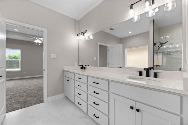 full bath featuring marble finish floor, a sink, baseboards, and double vanity