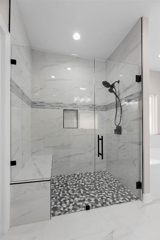 bathroom featuring a stall shower and marble finish floor