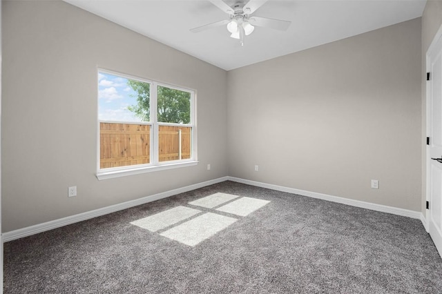 carpeted spare room with baseboards and a ceiling fan