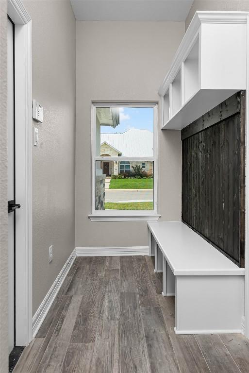 mudroom with dark wood-type flooring and baseboards