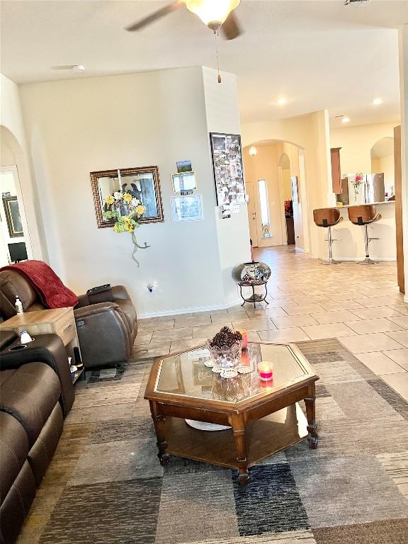 living room with light tile patterned floors and ceiling fan