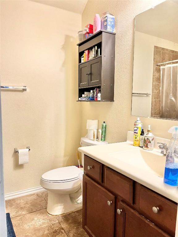 bathroom featuring vanity, toilet, and tile patterned floors