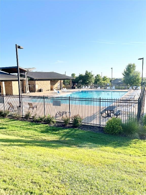 view of swimming pool with a lawn