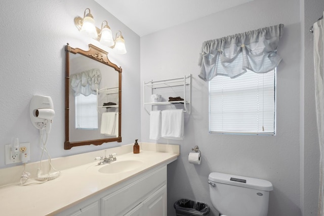 bathroom with plenty of natural light, vanity, and toilet