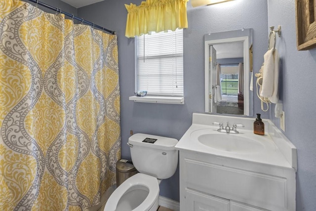 full bath featuring toilet, vanity, and a healthy amount of sunlight